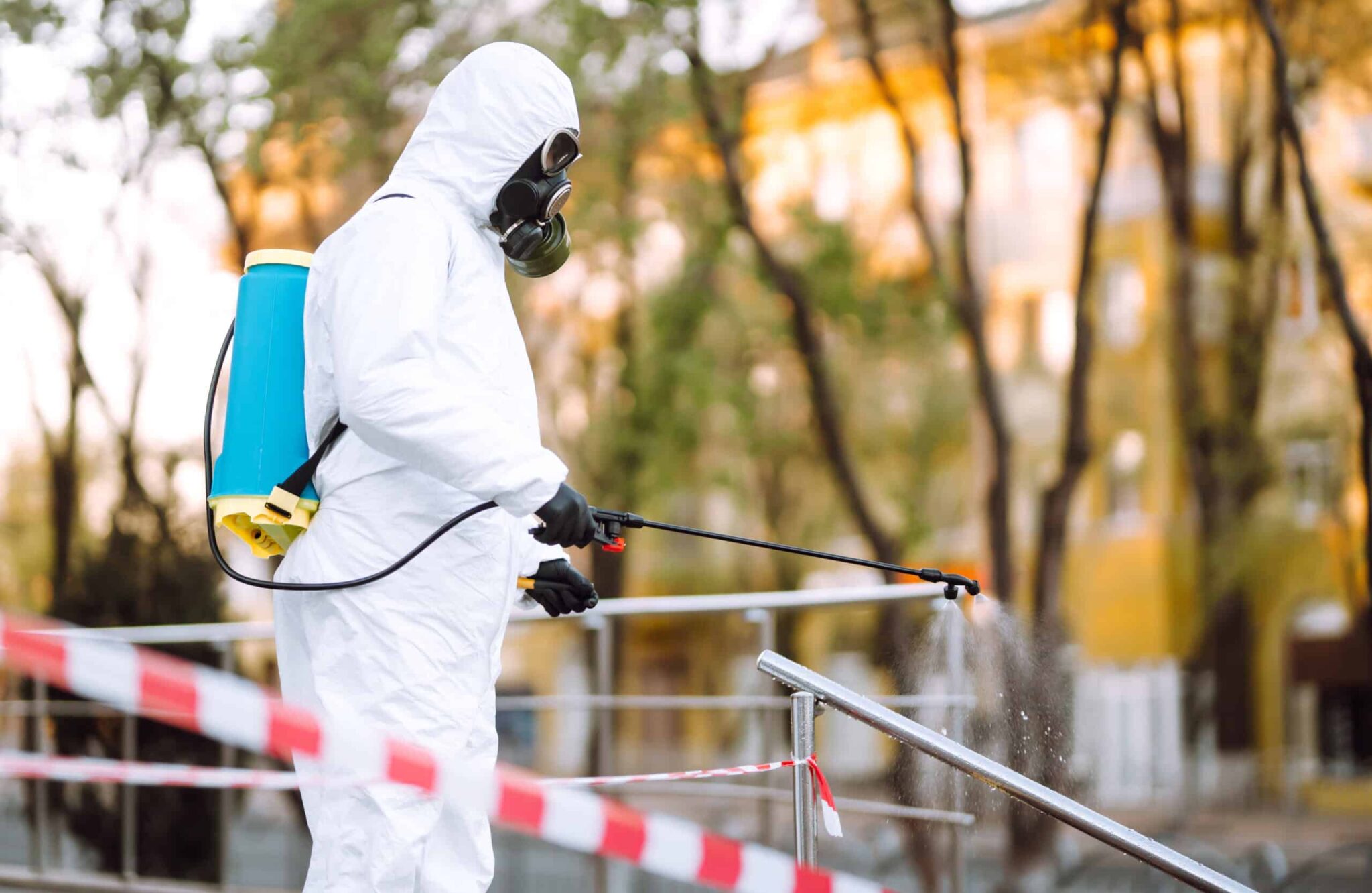 man-in-protective-suit-and-mask-sprays-disinfector-2025-03-08-14-14-19-utc-scaled